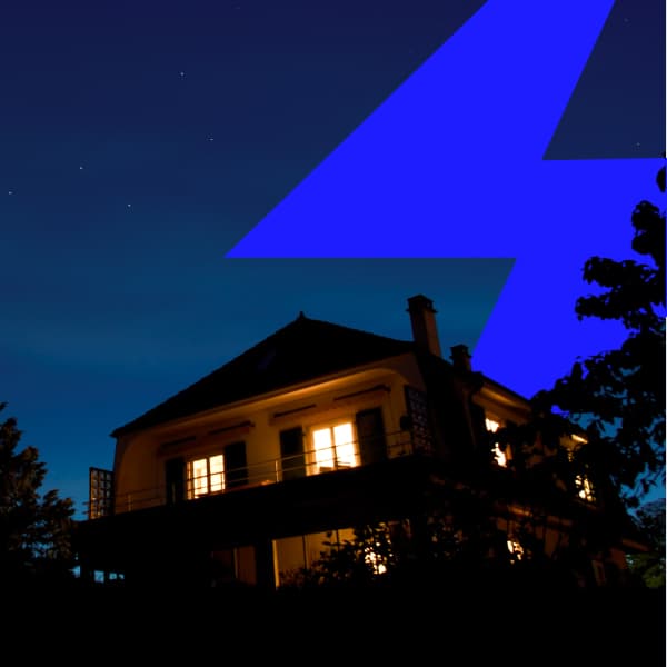 Home at night with lights on during a power outage
