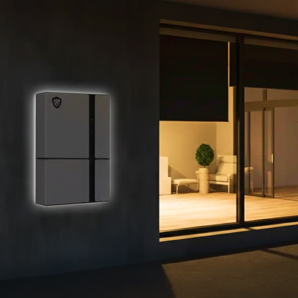 Home battery on an exterior wall at night