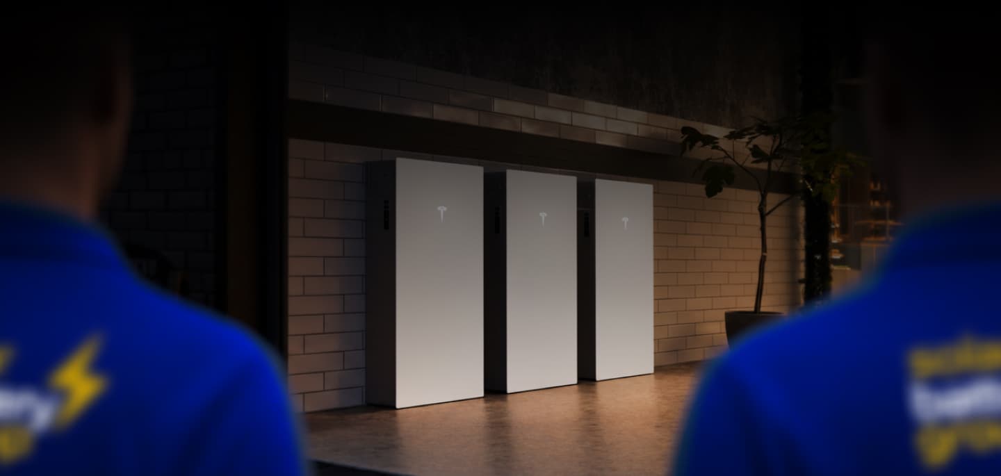 Solar Battery Group installers in front of three installed Powerwalls