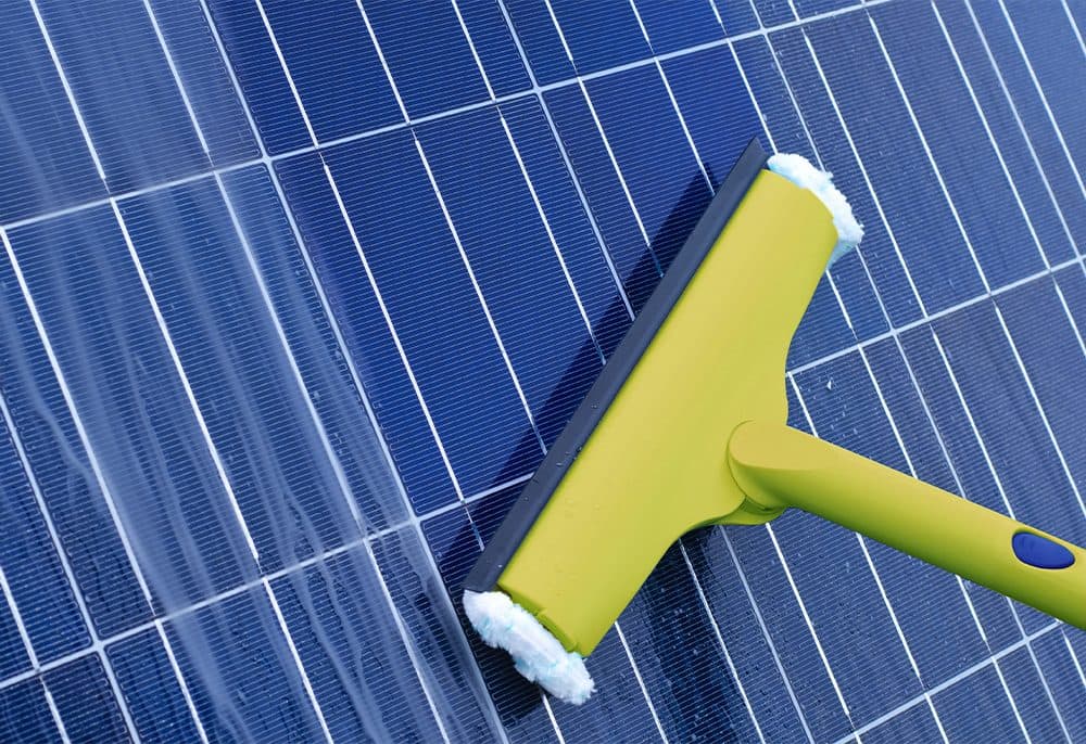 Squeegee cleaning the surface of a solar panel